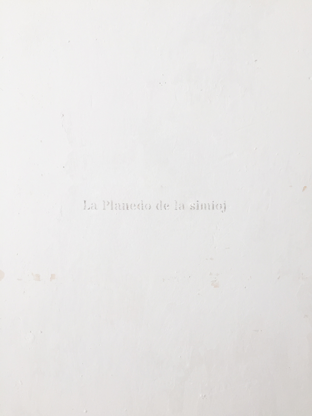 The words 'La planedo de la simioj' engraved on the wall