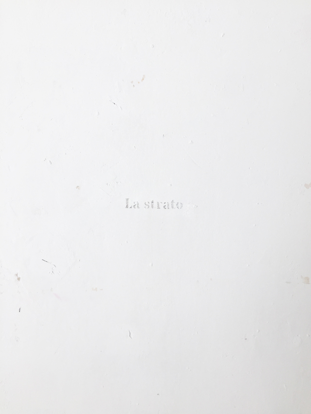 The words 'La strato' engraved on the wall